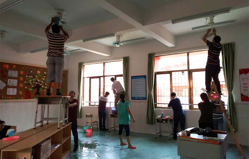 华体会体育志愿者及家长拆洗风扇和擦拭窗户